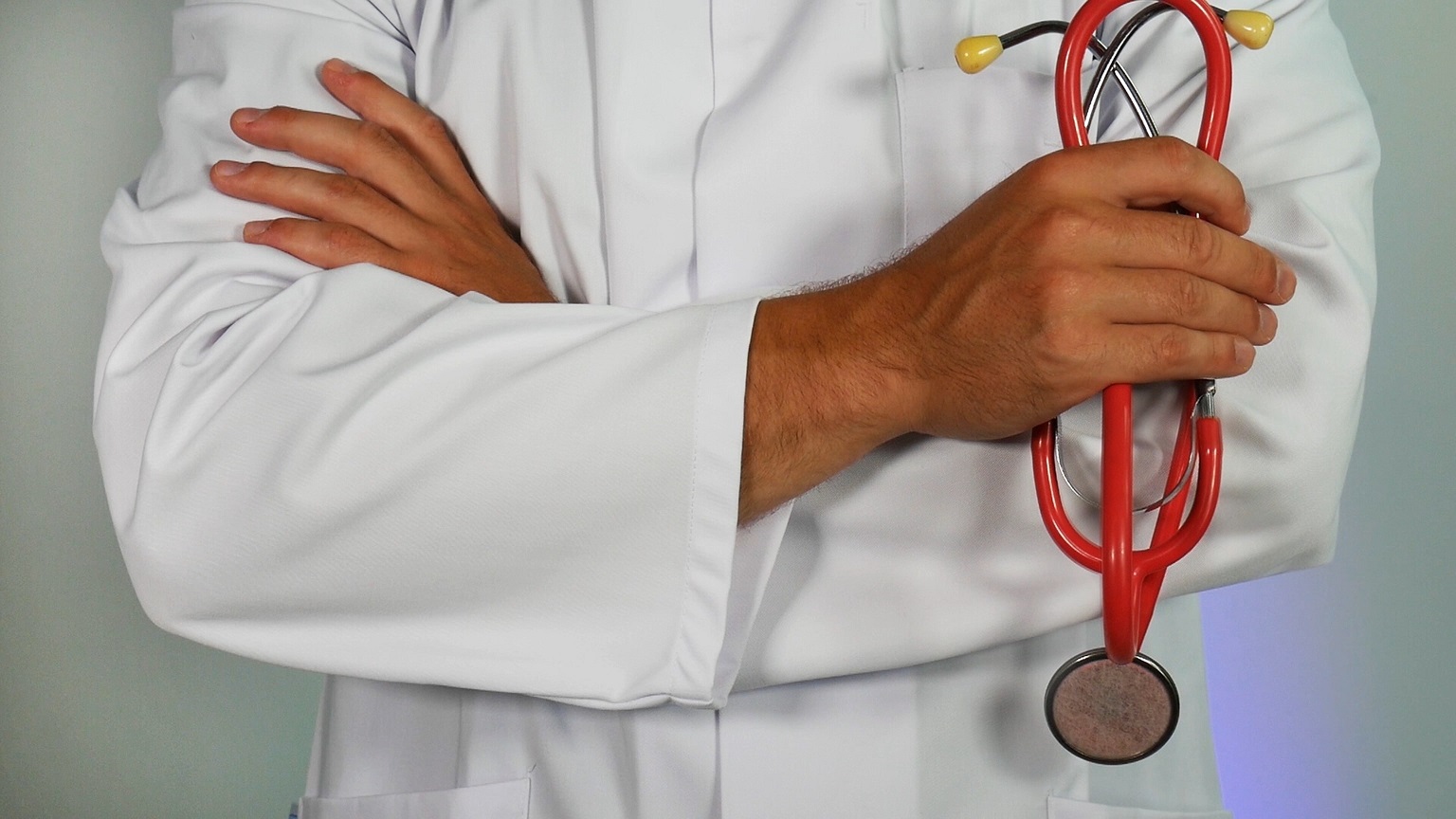 Doctor in lab coat holding stethoscope